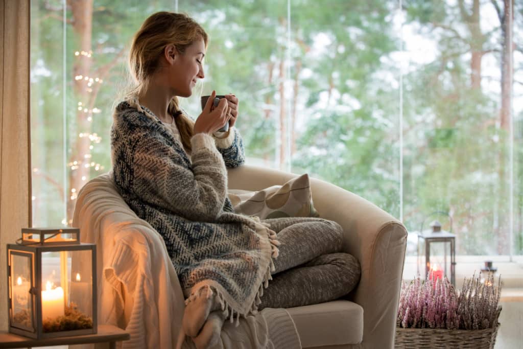 Wool Yarn, Top 5 things you should know about it 4 Young woman sitting home by the window in a wool sweater